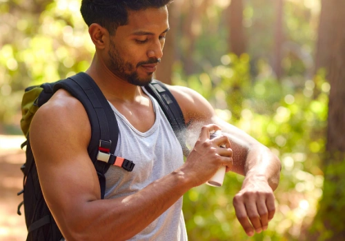 Traveler using insect repellent to help prevent mosquito-borne diseases while traveling abroad