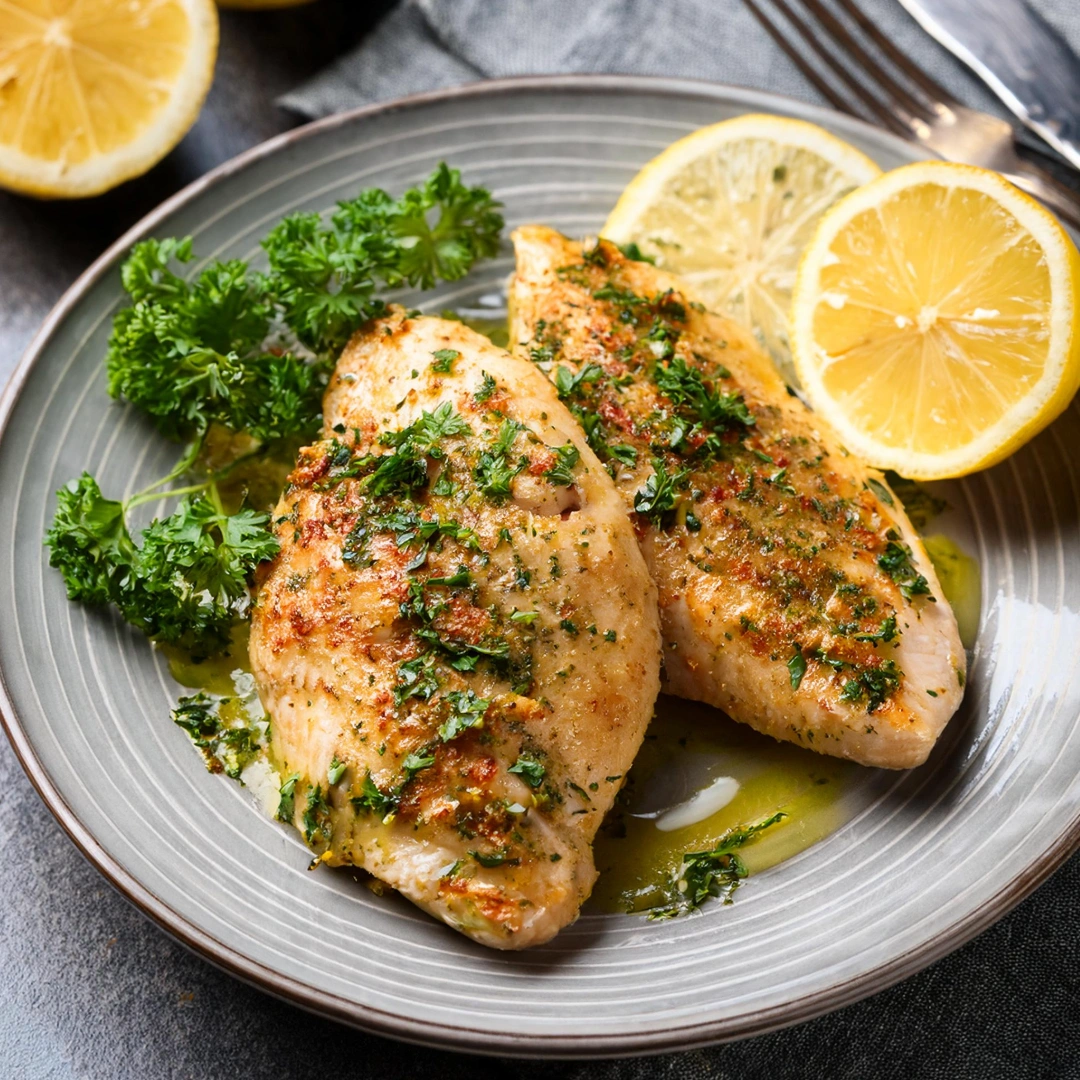 baked chicken breasts with garnish and lemons