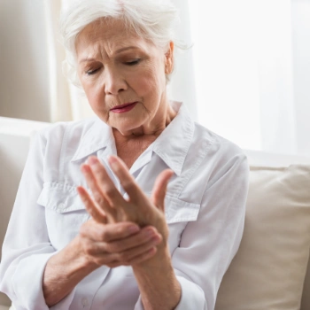 Older woman with achy hand consistent with osteoarthritis
