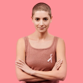 Breast cancer survivor with shaved head and pink ribbon