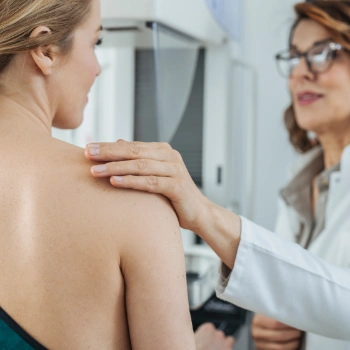 Female doctor assisting a patient with her mammogram exam