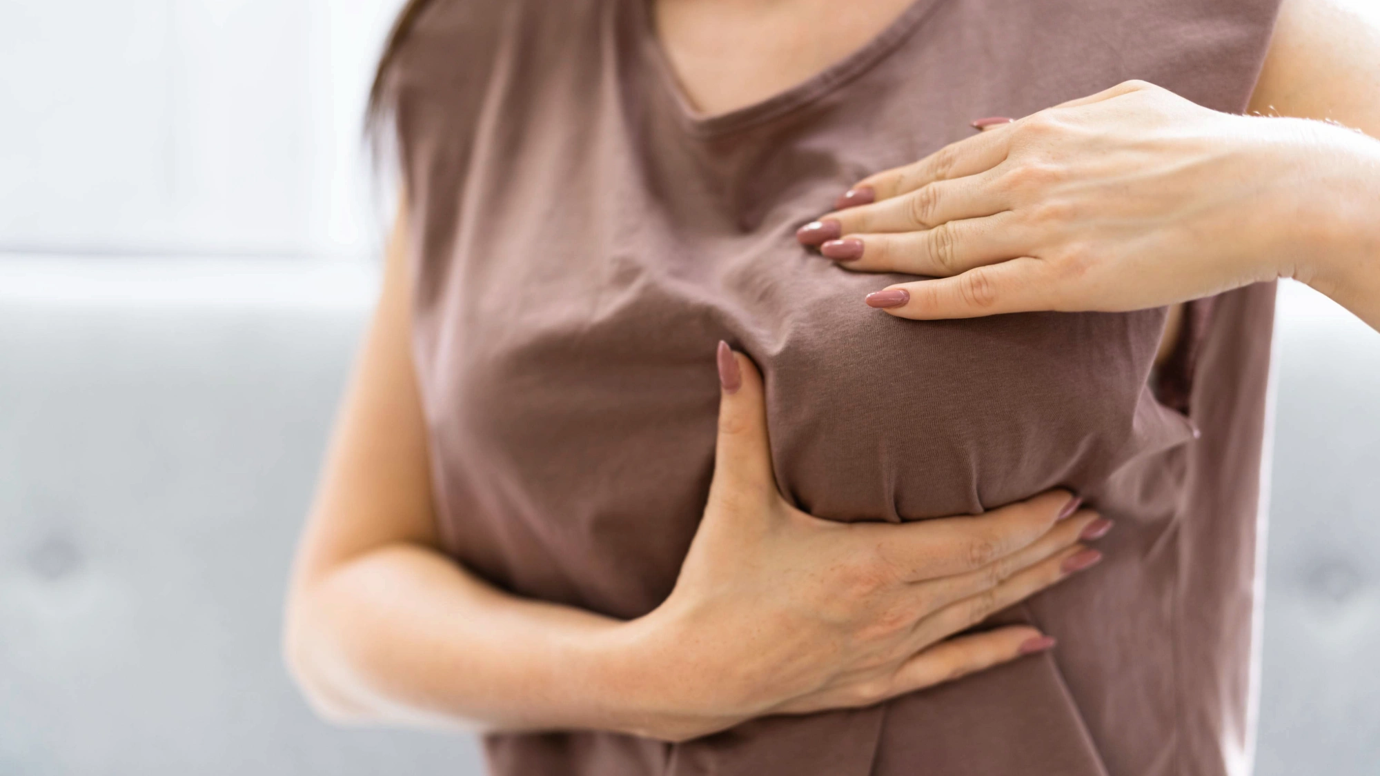 Woman checking her breasts for skin changes or rash