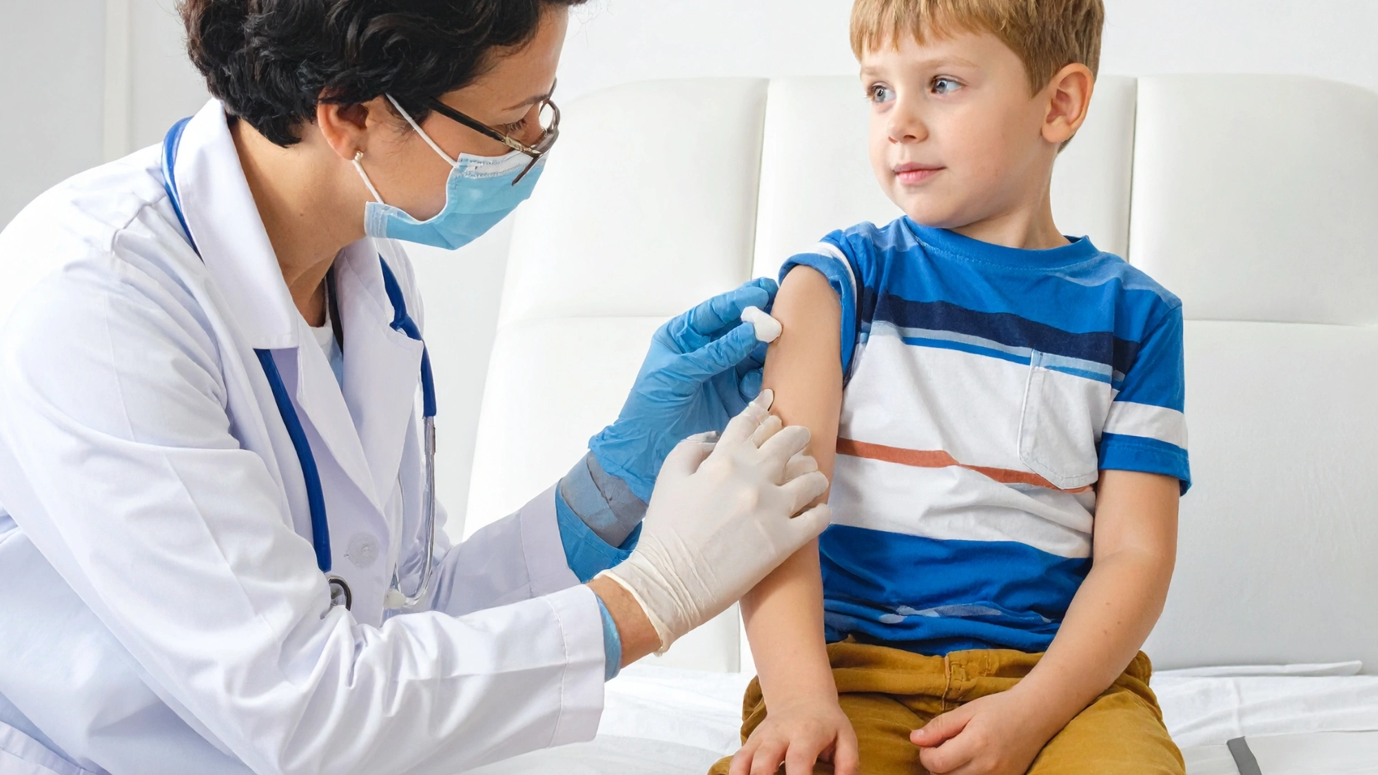 Young child receiving an immunization from a female doctor