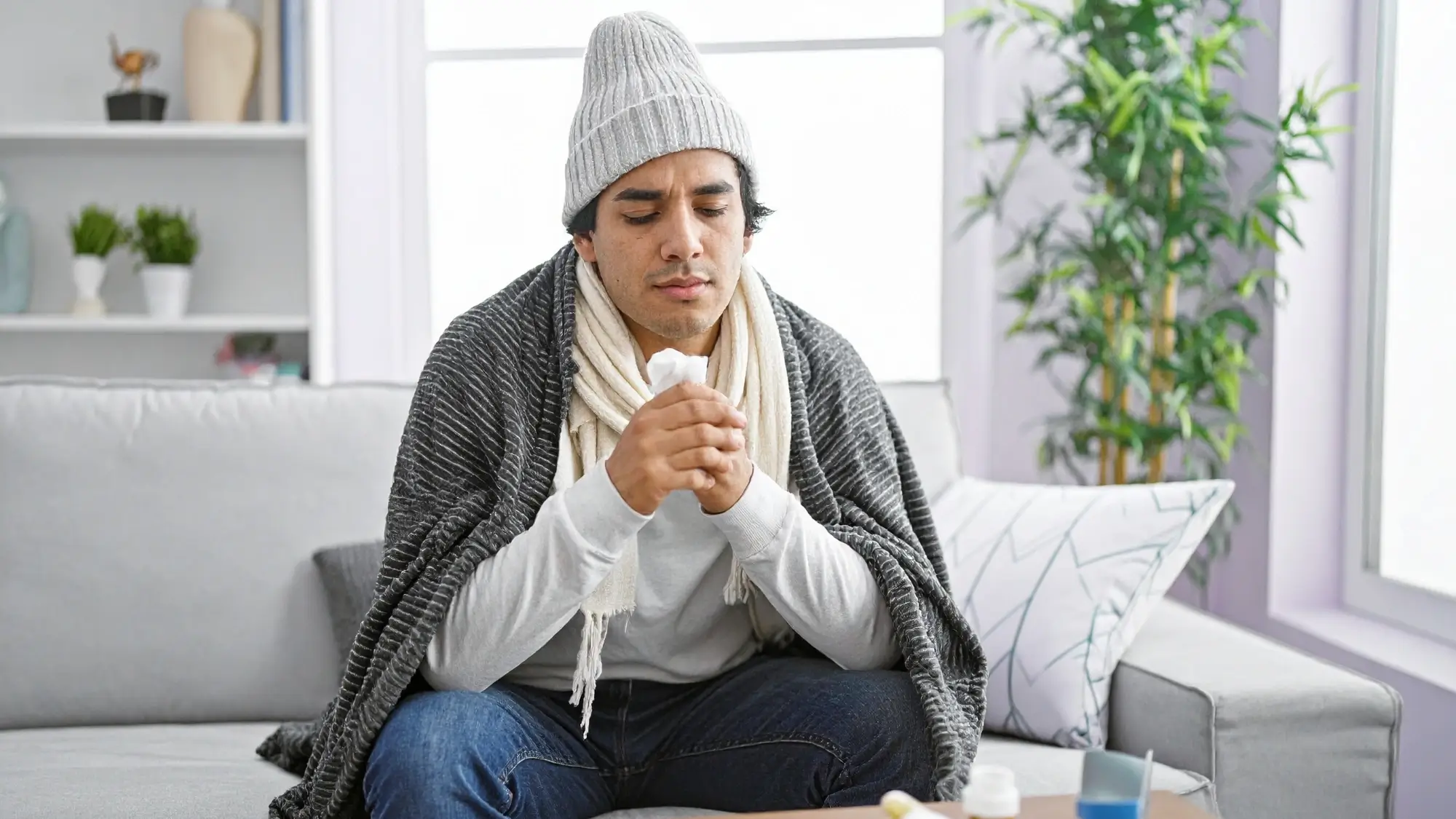 Person resting indoors feeling unwell without a fever during winter
