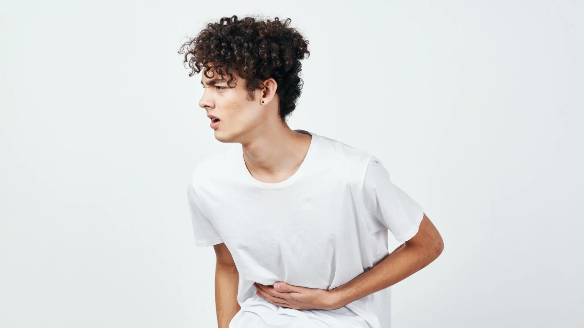 Young adult man with a stomach ache likely due to an ulcer.