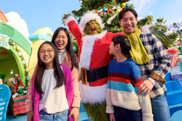 Family posing with the Grinch