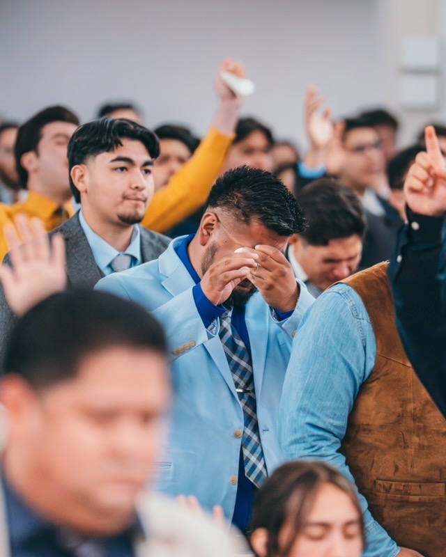 Young people and church members praying together at Voice of Truth Tabernacle