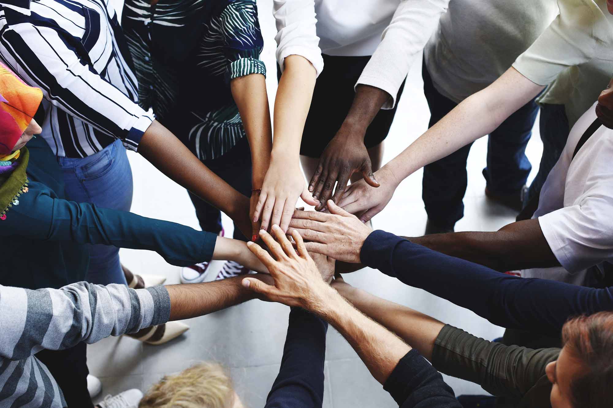Hands of diverse people coming together.