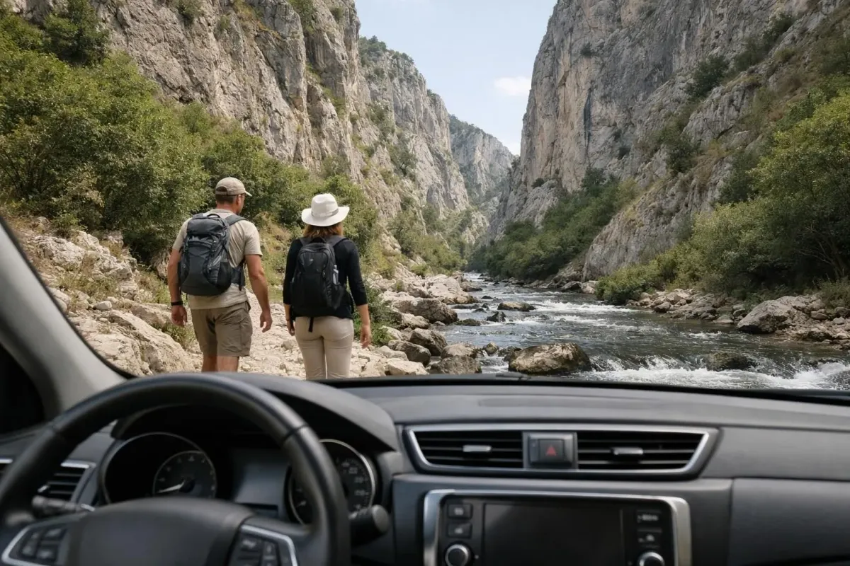 Two hikers exploring a scenic mountain gorge with a rushing river.