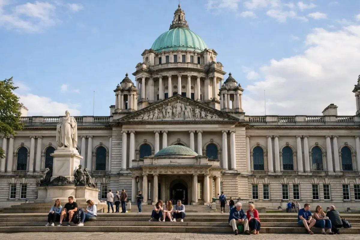 Belfast City Hall avec sa façade victorienne majestueuse, dôme de cuivre vert et murs en pierre de Portland, visiteurs sur les marches de Donegall Square sous le soleil