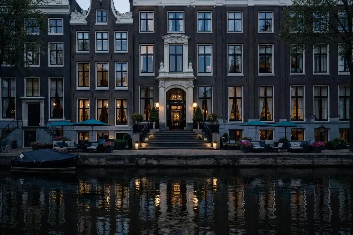 Façade élégante du Waldorf Astoria Amsterdam sur le Herengracht avec ses pignons ornementés et son entrée de luxe reflétée dans le canal