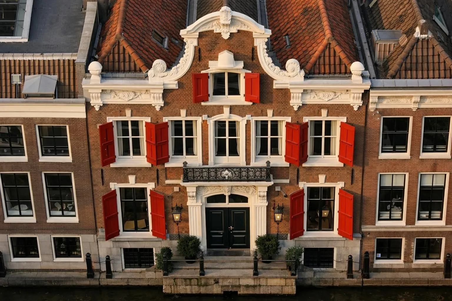 Façade typique d'un hôtel de charme avec ses fenêtres caractéristiques à Amsterdam, aux Pays-Bas, dans une ambiance chaleureuse de quartier historique