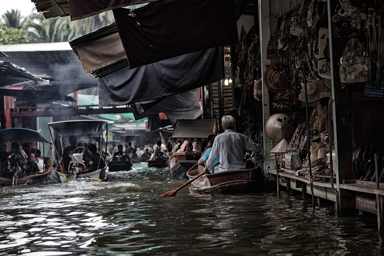 Bateau coloré chargé de fruits et légumes sur les canaux de Bangkok en Thaïlande, avec l'atmosphère authentique des marchés flottants