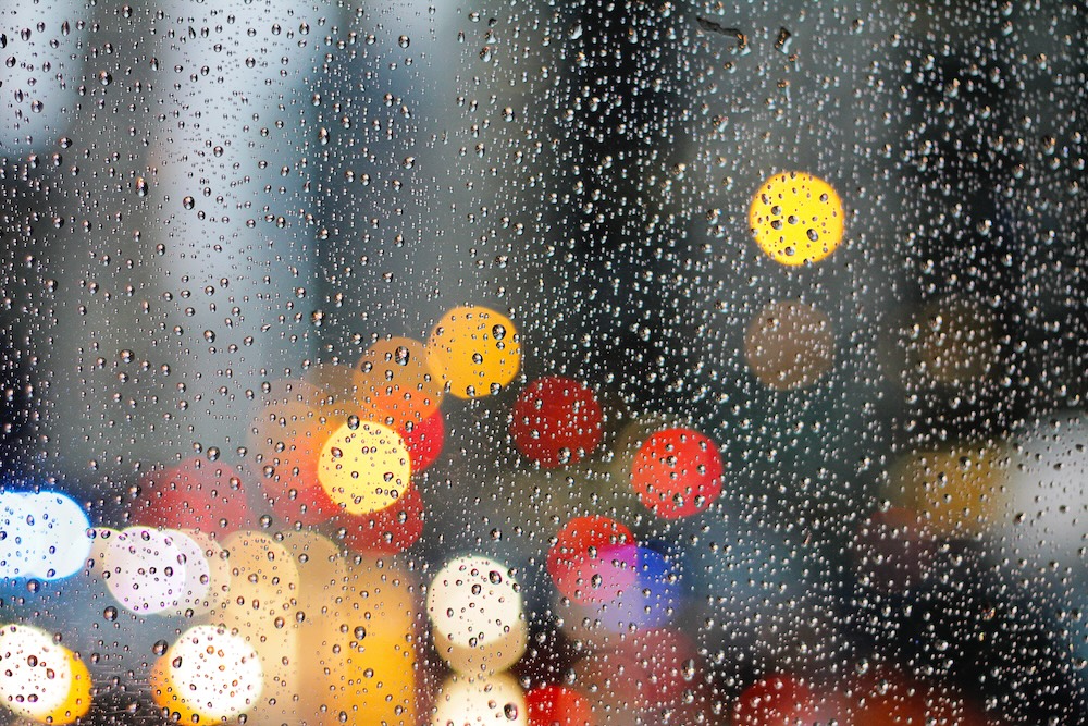 Rue pavée de Nantes sous la pluie, atmosphère grise et humide typique de la ville en hiver, reflets mouillés sur les pavés