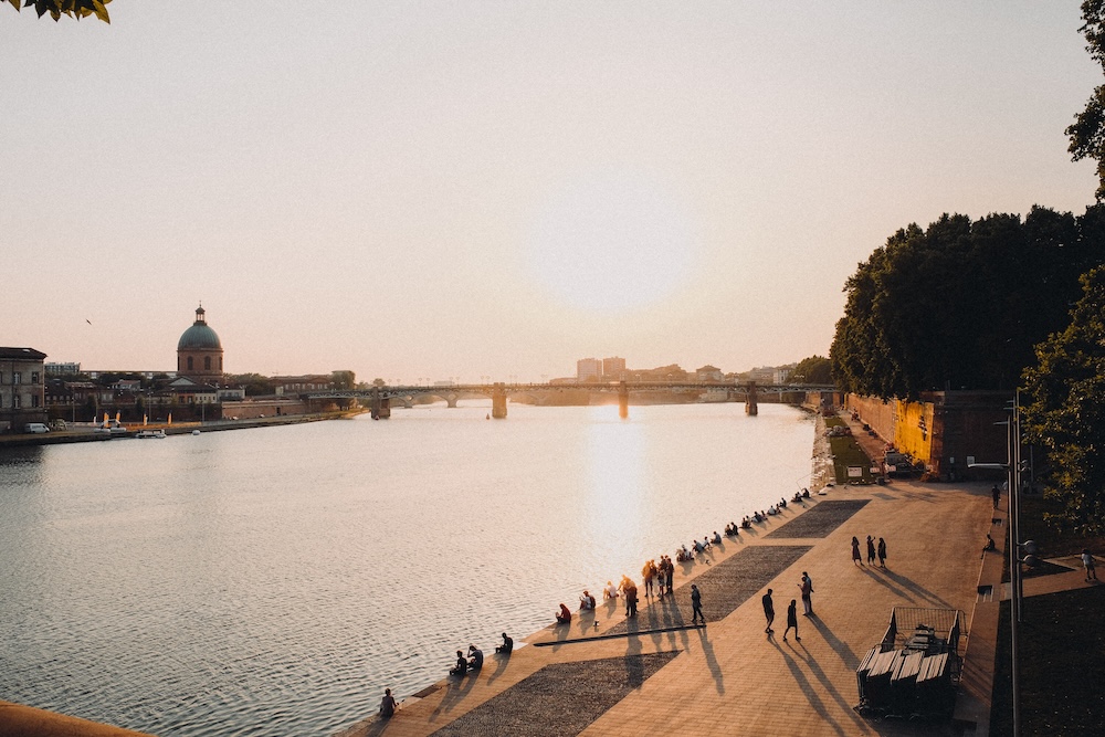 Les toits roses de Toulouse baignés dans la lumière dorée de l'automne, entre architecture historique et feuillages aux teintes chaudes
