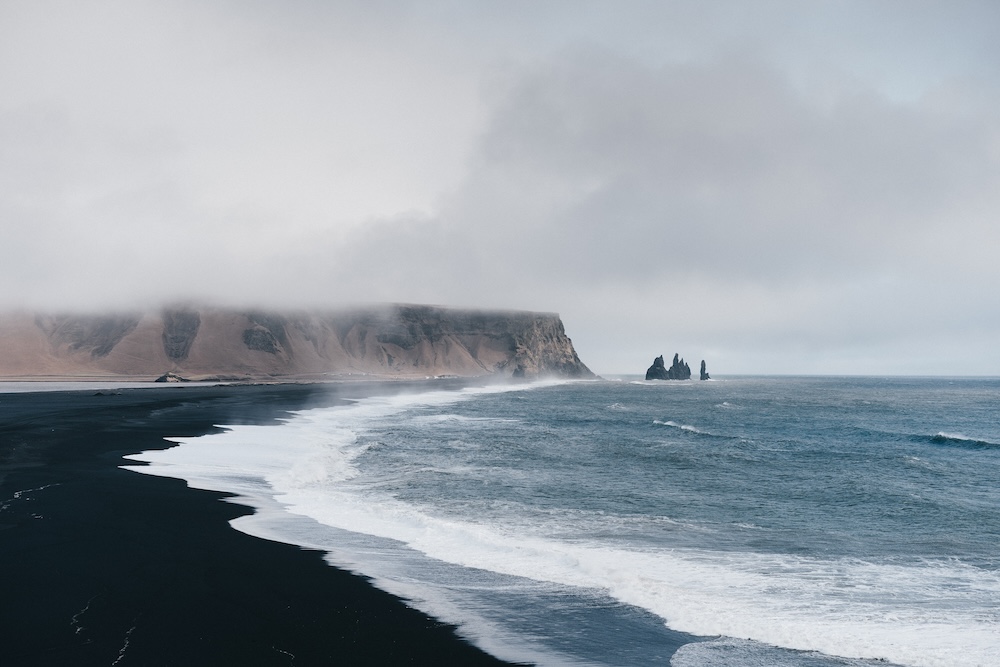 Côte rocheuse islandaise baignée de lumière douce, avec formations géologiques caractéristiques et atmosphère sauvage de Reykjavik