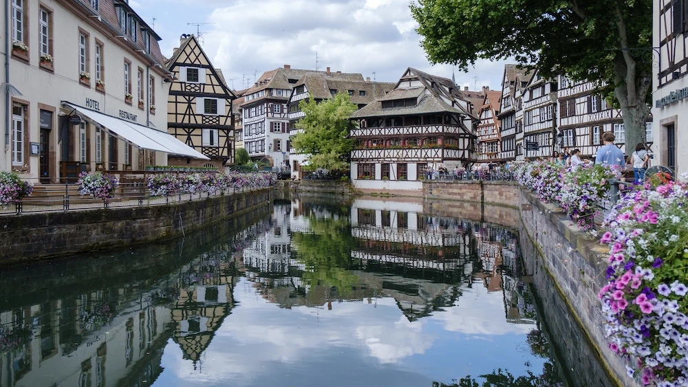 Façade colorée d'un immeuble strasbourgeois avec ses volets typiques, illustrant l'architecture chaleureuse de la ville alsacienne