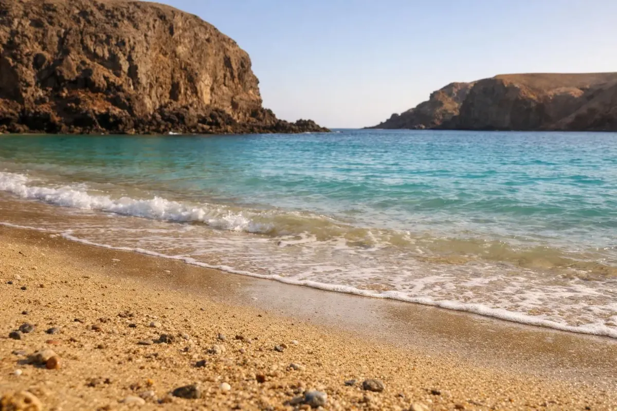 Des eaux turquoise paisibles, des falaises escarpées et une plage de sable doré.