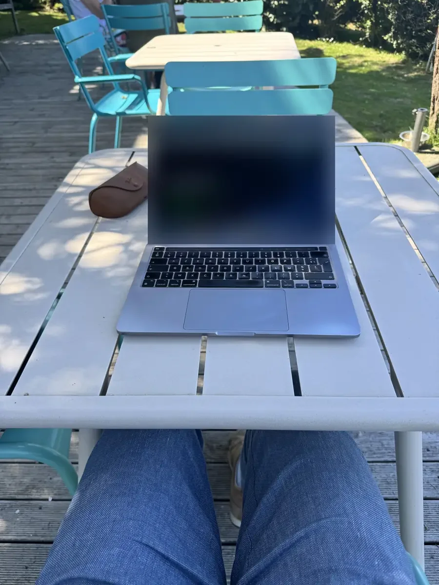 Ordinateur portable sur une table de la terrasse du Cise face au jardin et à la mer