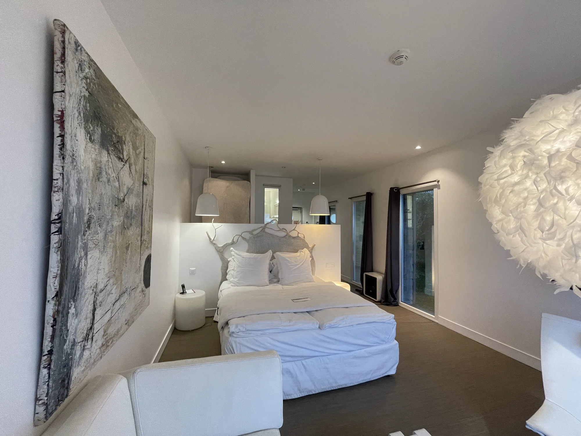 Chambre supérieure panoramique de l'hôtel Le Cise à Ault, tête de lit sculptée et suspension en plumes