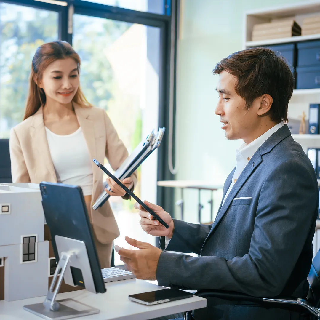 two employees holding documents each