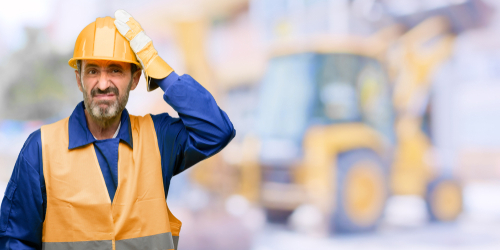 man in orange construction hat and safety vest with confused look on his face