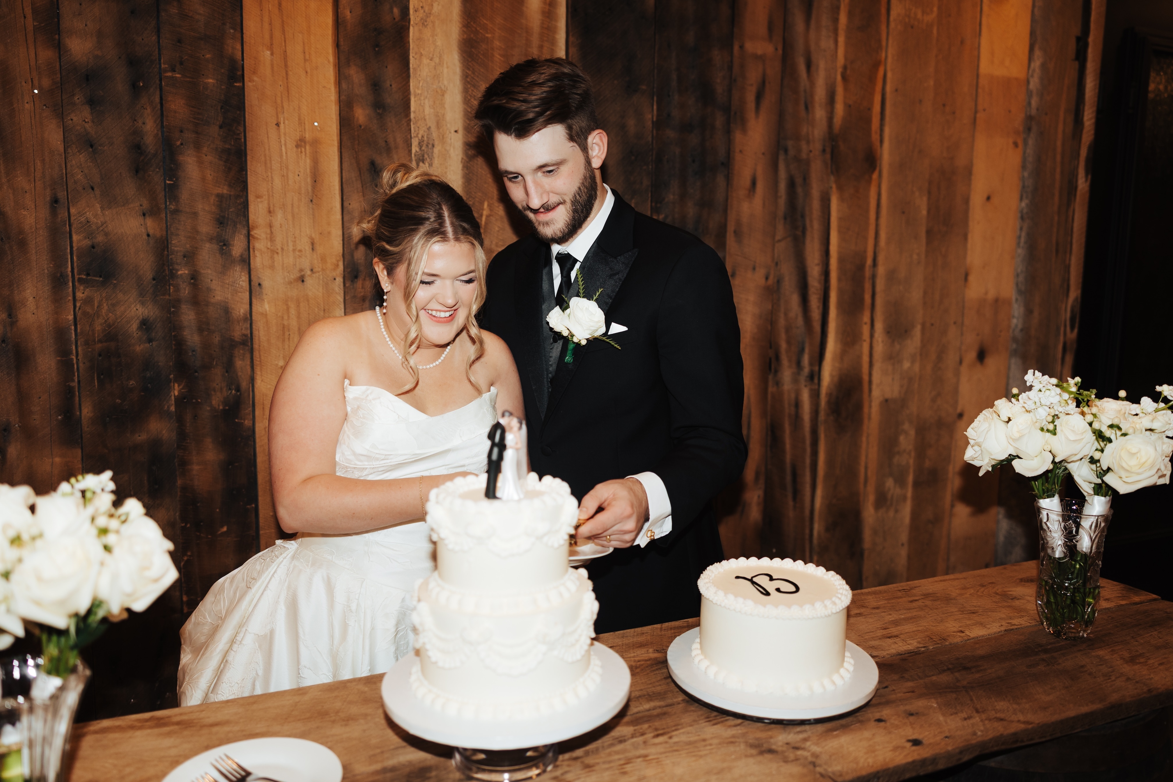 Bride and Groom slicing their two-tier wedding cake at Rick's Chop House private dining room in historic downtown McKinney, Texas. Photo by Taylor Salerno Photography