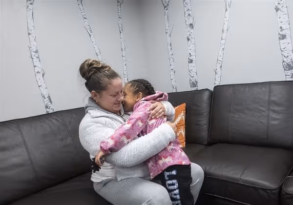 mother holding child on corner sofa