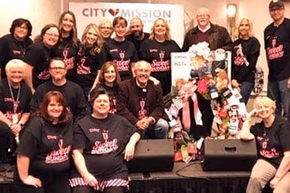 3 male City Mission Resident give a group hug