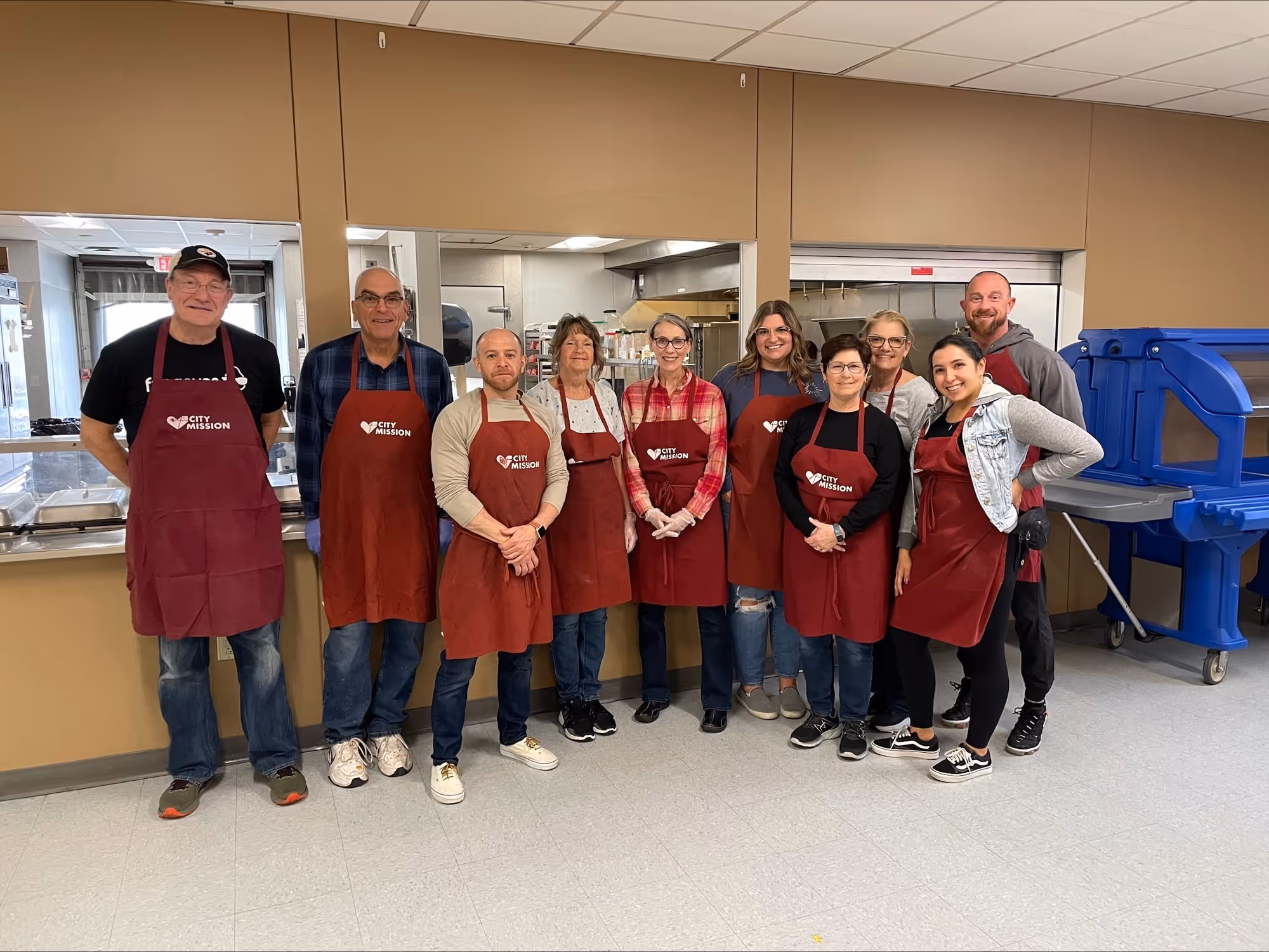 3 youthful volunteers serve food to City Mission residents