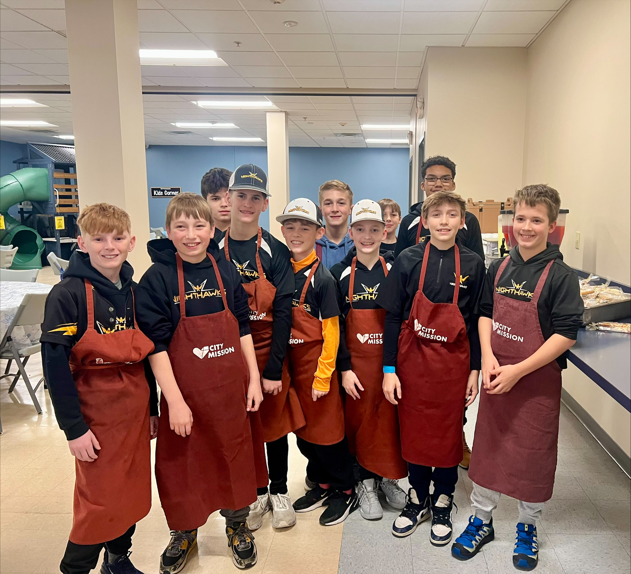 5 youthful volunteers in the cafeteria alongside CEO Dean Gartland