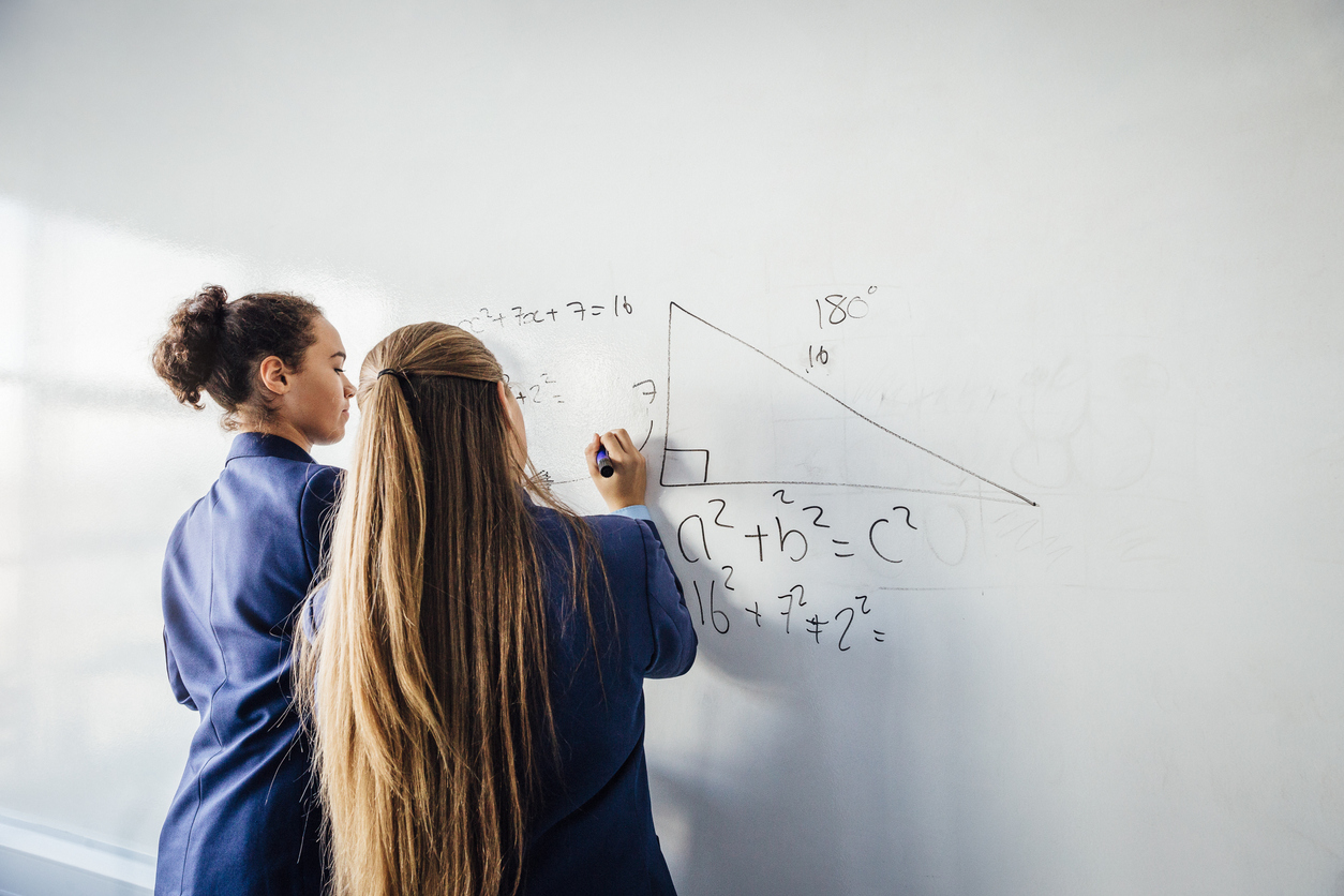 Girls in school doing calculations on a whiteboard