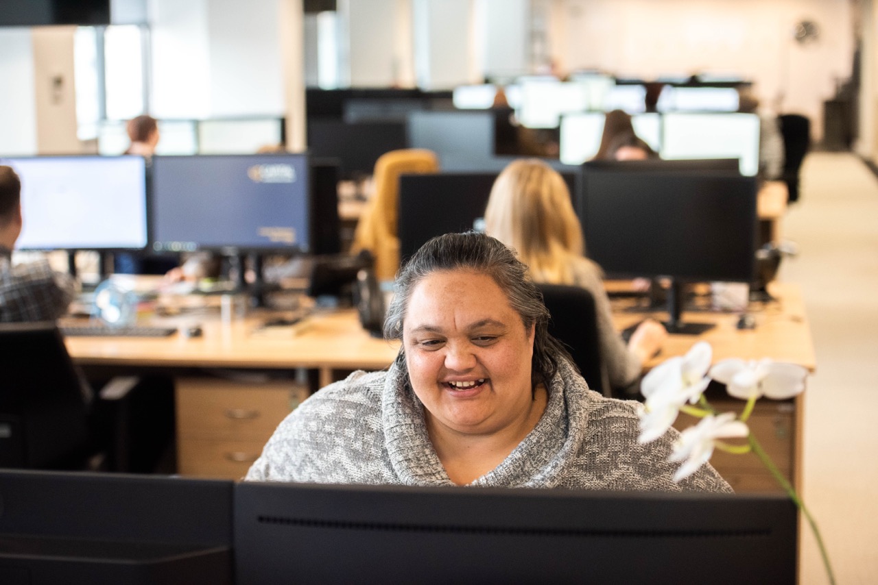 A colleague smiling from behind a desk