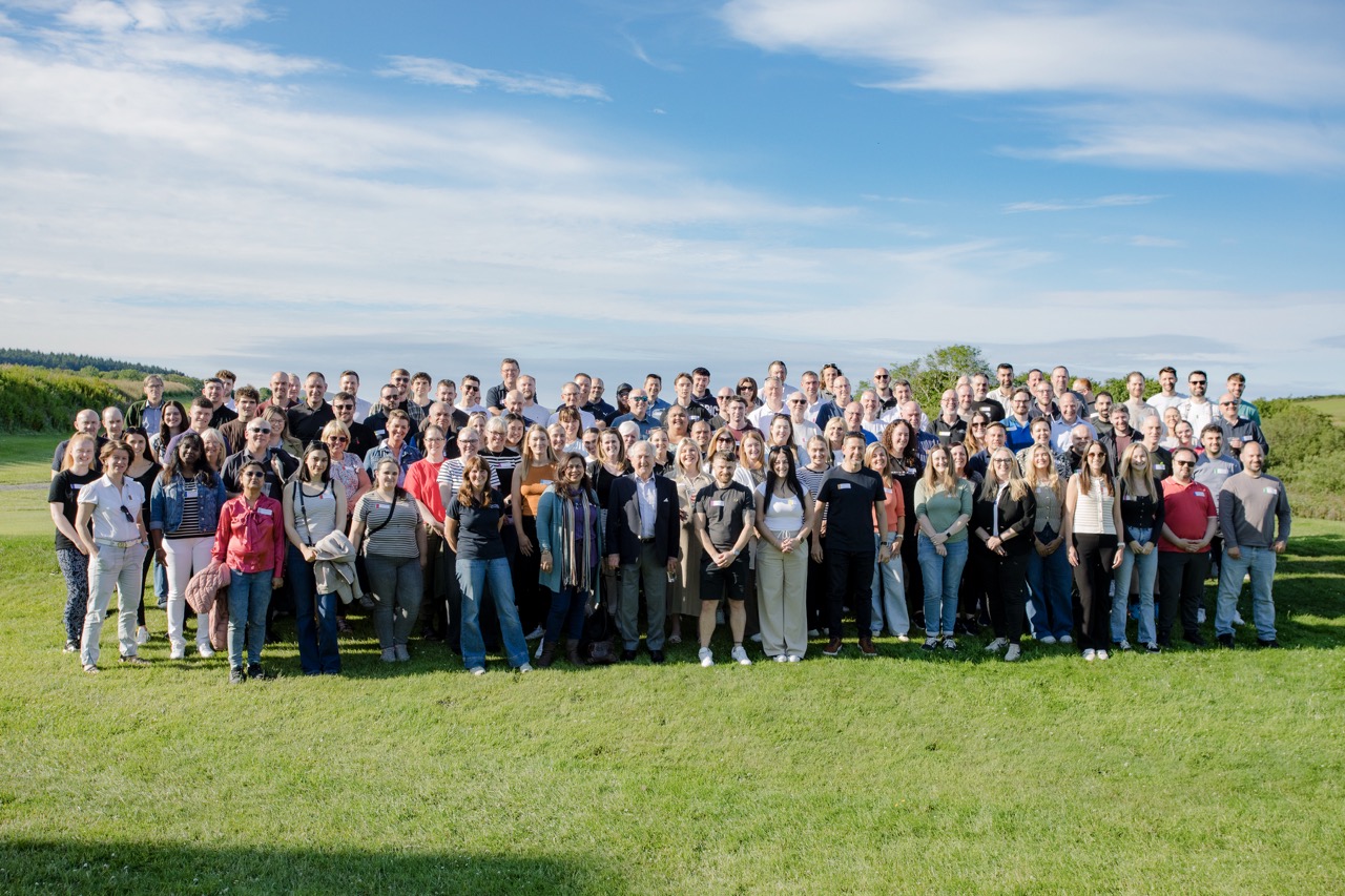 Gathering of Isle of Man employees in a grassy sunny setting