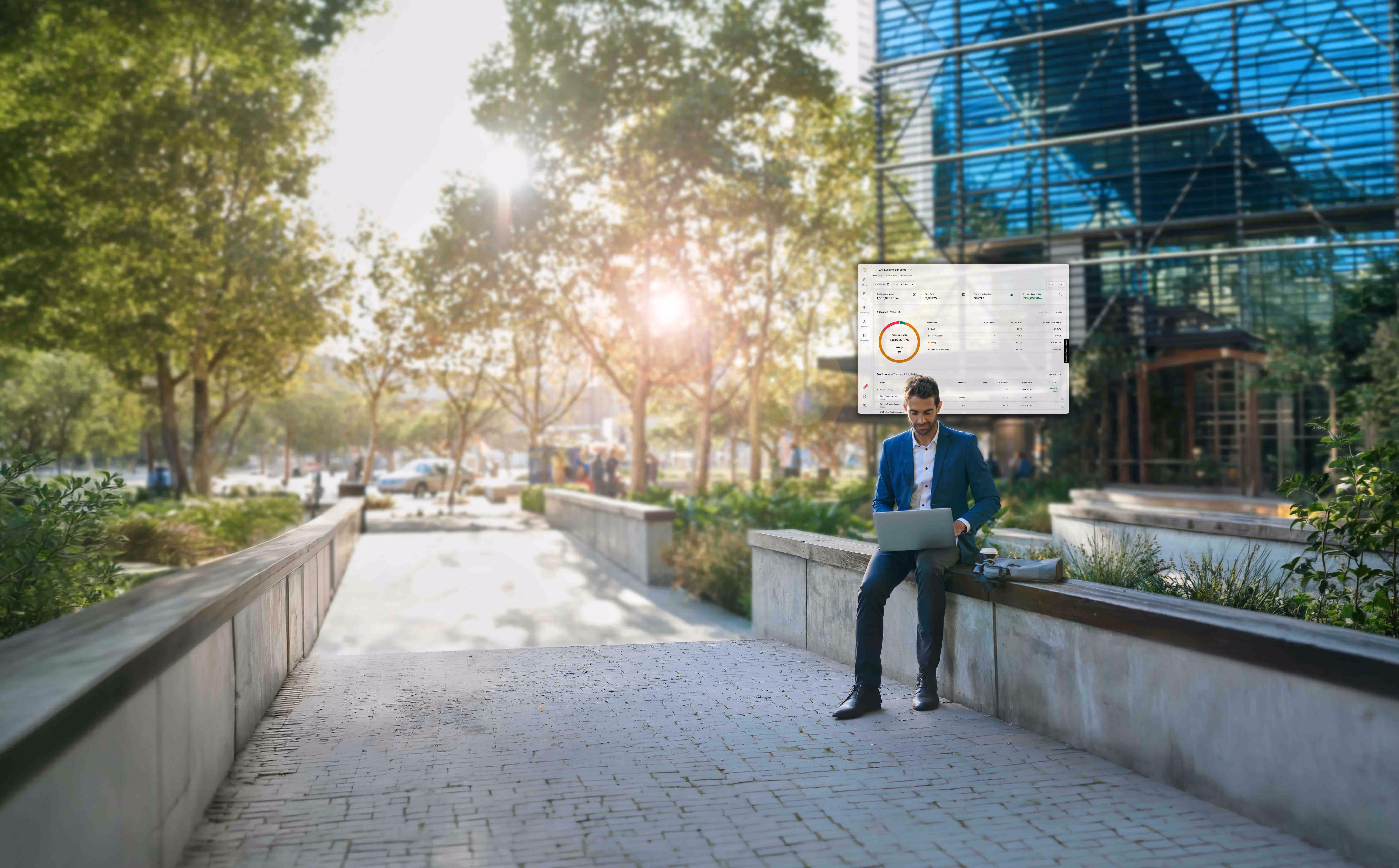 Man in a blue suit sitting on a concrete ledge outside near a modern glass building, working on a laptop with a digital interface of charts and data displayed above him, surrounded by trees and sunlight.