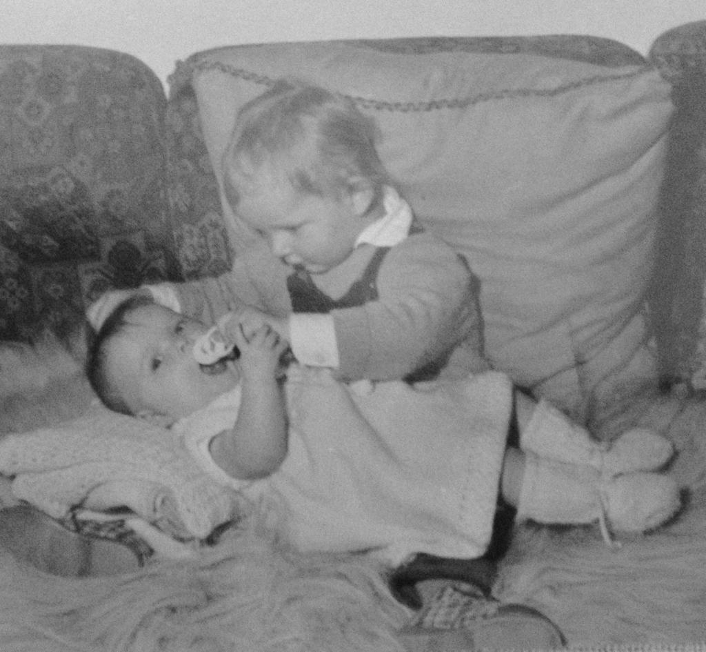 Altes Schwarz-Weiß-Foto: zwei Kleinkinder spielen auf einem Sofa