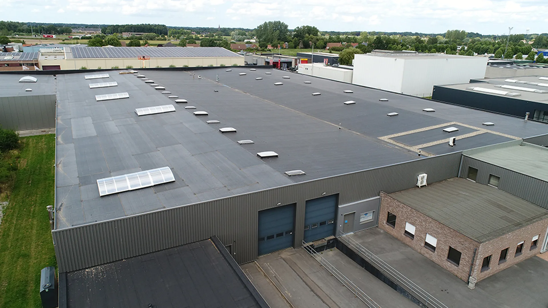 Industriële dakafdichting op een groot plat dak met lichtkoepels – Van Hoof Dakwerken