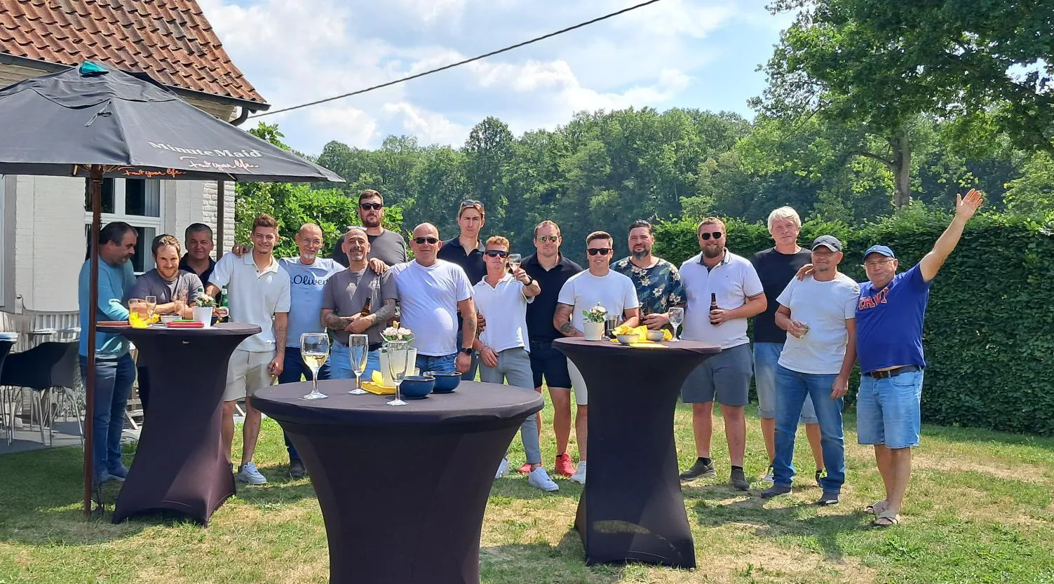 Team Van Hoof tijdens een zomerse teambuilding, medewerkers poseren samen buiten met een drankje"