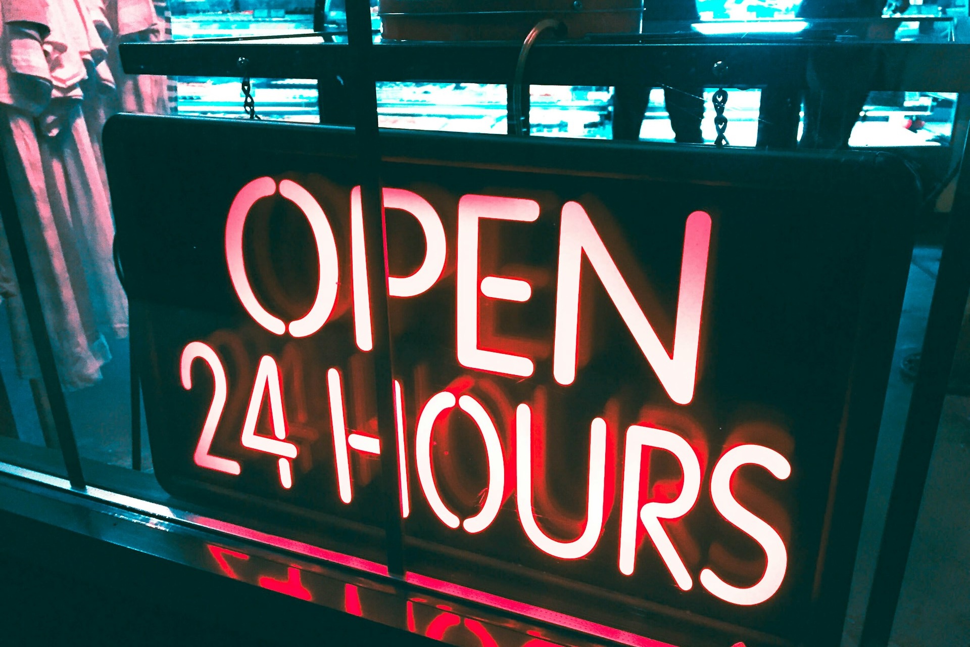 An "Open" 24 hours sign in a physical store alluding to the 24/7 wholesale ordering capability a B2B eCommerce platform offers. 