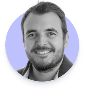 Retrato en primer plano de un hombre sonriente con barba y cabello corto.