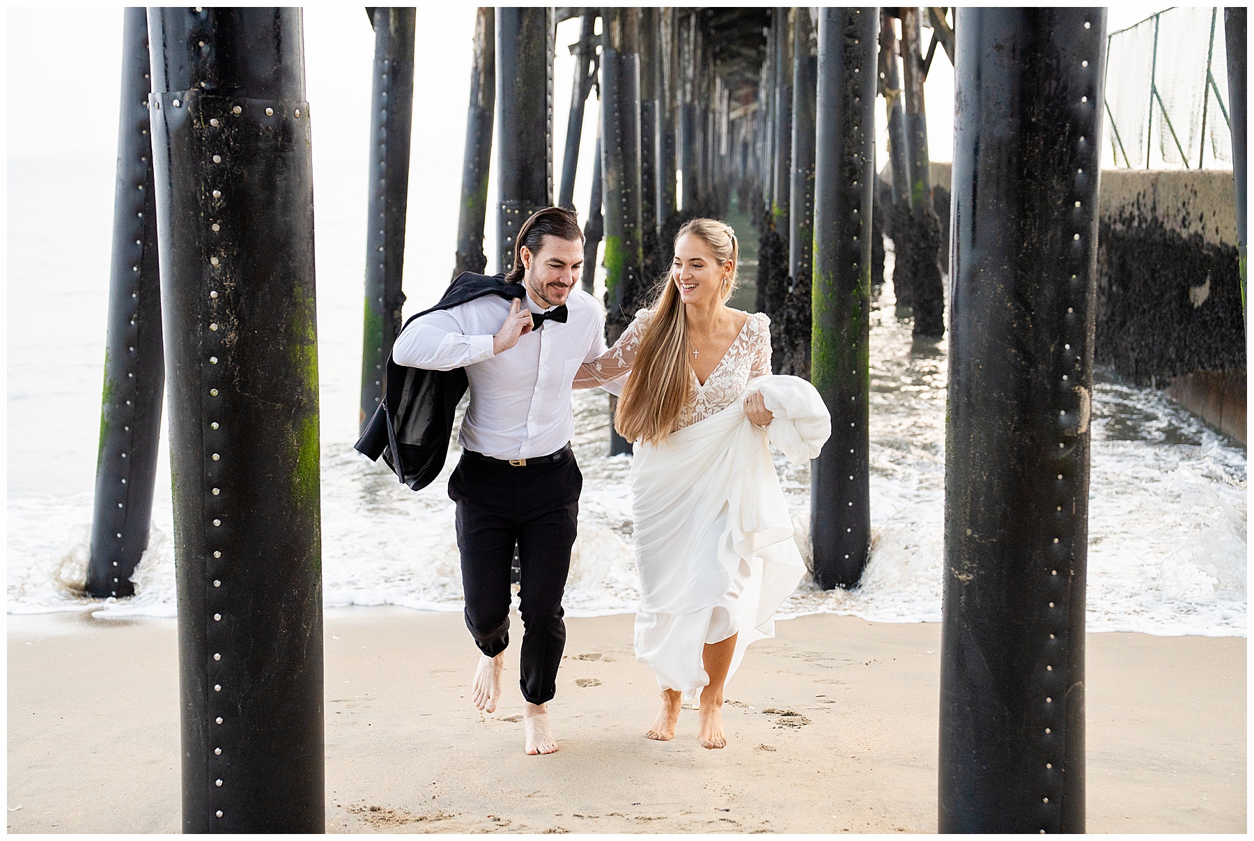Romantic Seal Beach engagement portraits with a second-hand white dress, fitted white gown, and classic black suit. Coastal wedding photography with playful movement.