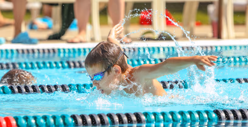 swim instructor and student during swim lessons in pool