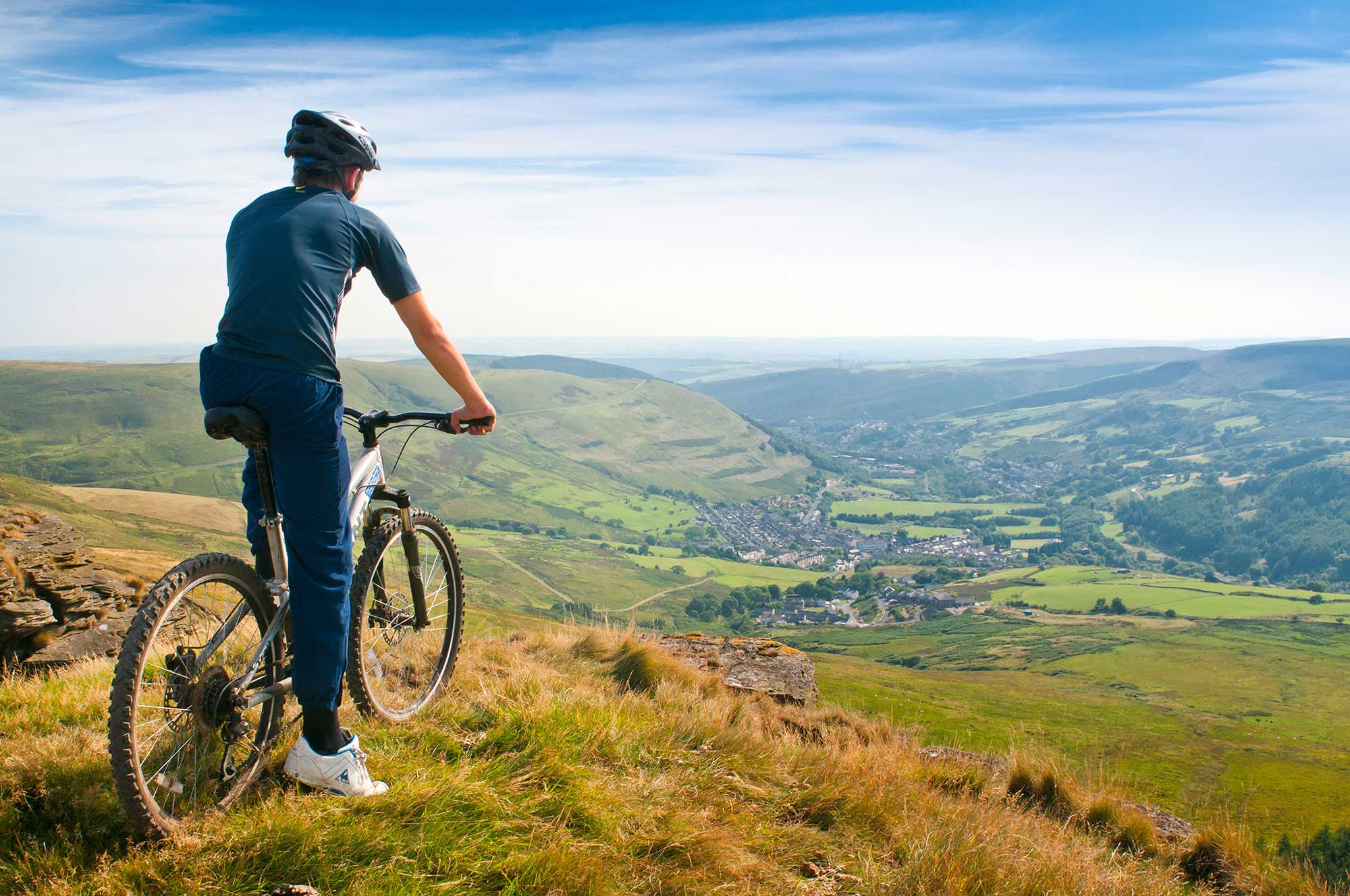 A mountain biker looking into the distant views of the valleys of Ogmore