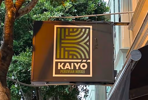 A sign hanging from the side of a building.