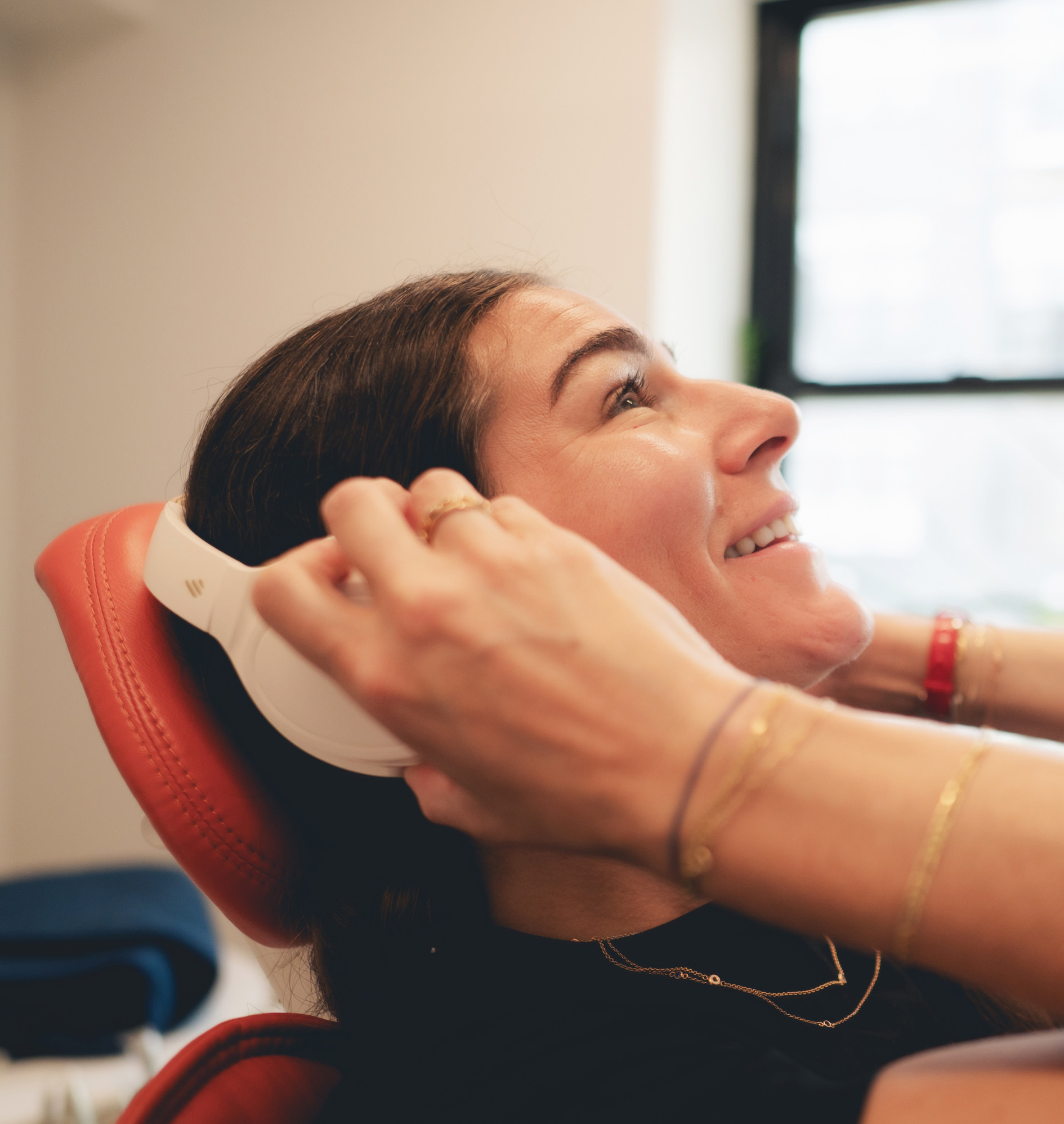 photo of a smiling patient wearing headphones and Dr. Lilya