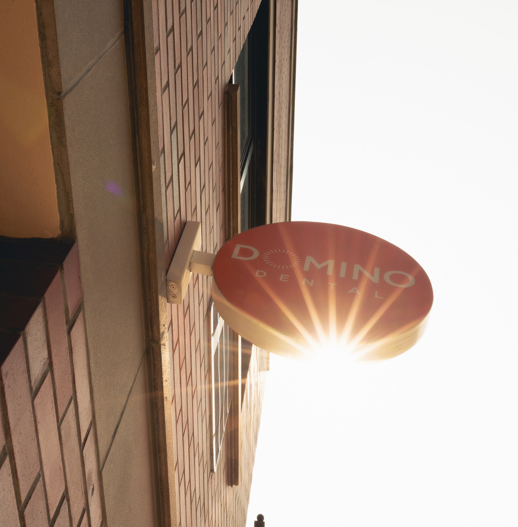 Photo of a bright wall with a mirror, sink, and artwork featuring the phrase "Treat People with Kindness"