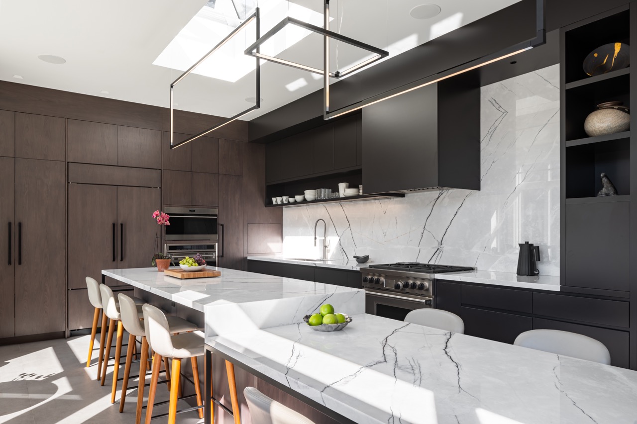 Stylish South Hill: Rich walnut cabinetry wraps the room floor to ceiling, framed by full-height steel windows and doors that flood the space with light