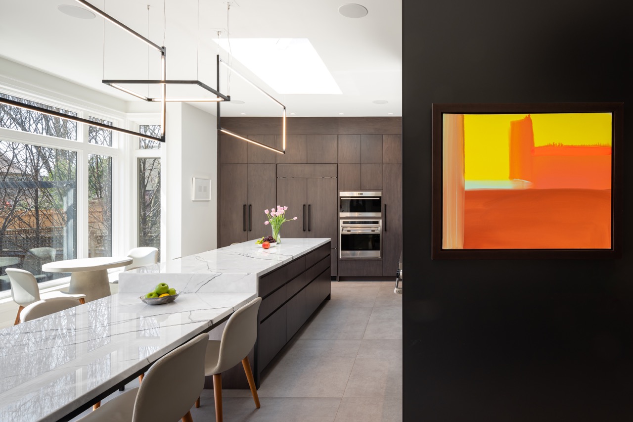 Stylish South Hill: Pops of citrus-toned art play off the warm wood tones, while polished stone flooring keeps the whole space grounded