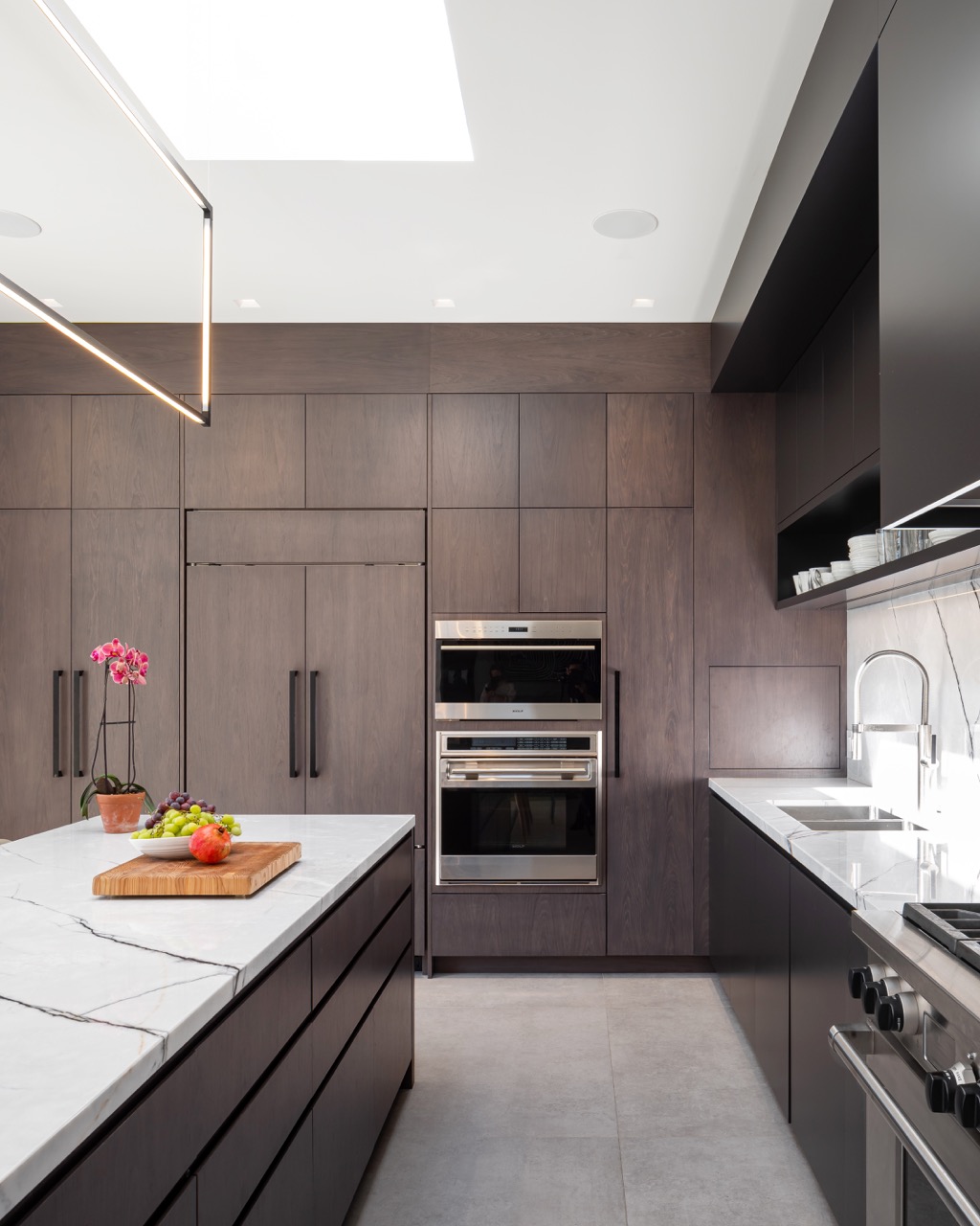 Stylish South Hill: Pops of citrus-toned art play off the warm wood tones, while polished stone flooring keeps the whole space grounded