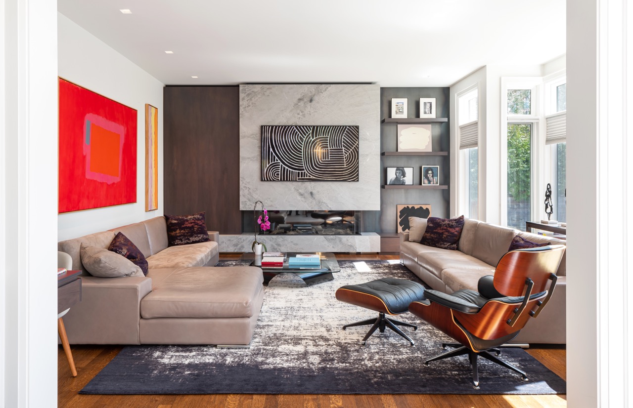 Stylish South Hill: Pops of citrus-toned art play off the warm wood tones, while polished stone flooring keeps the whole space grounded